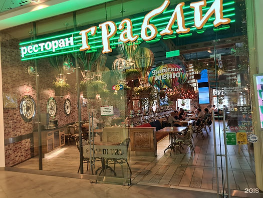 Wide angle view of a bustling Grably cafe with a variety of fresh dishes