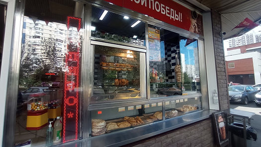 Eye-level view of a street vendor preparing kebabs on a grill